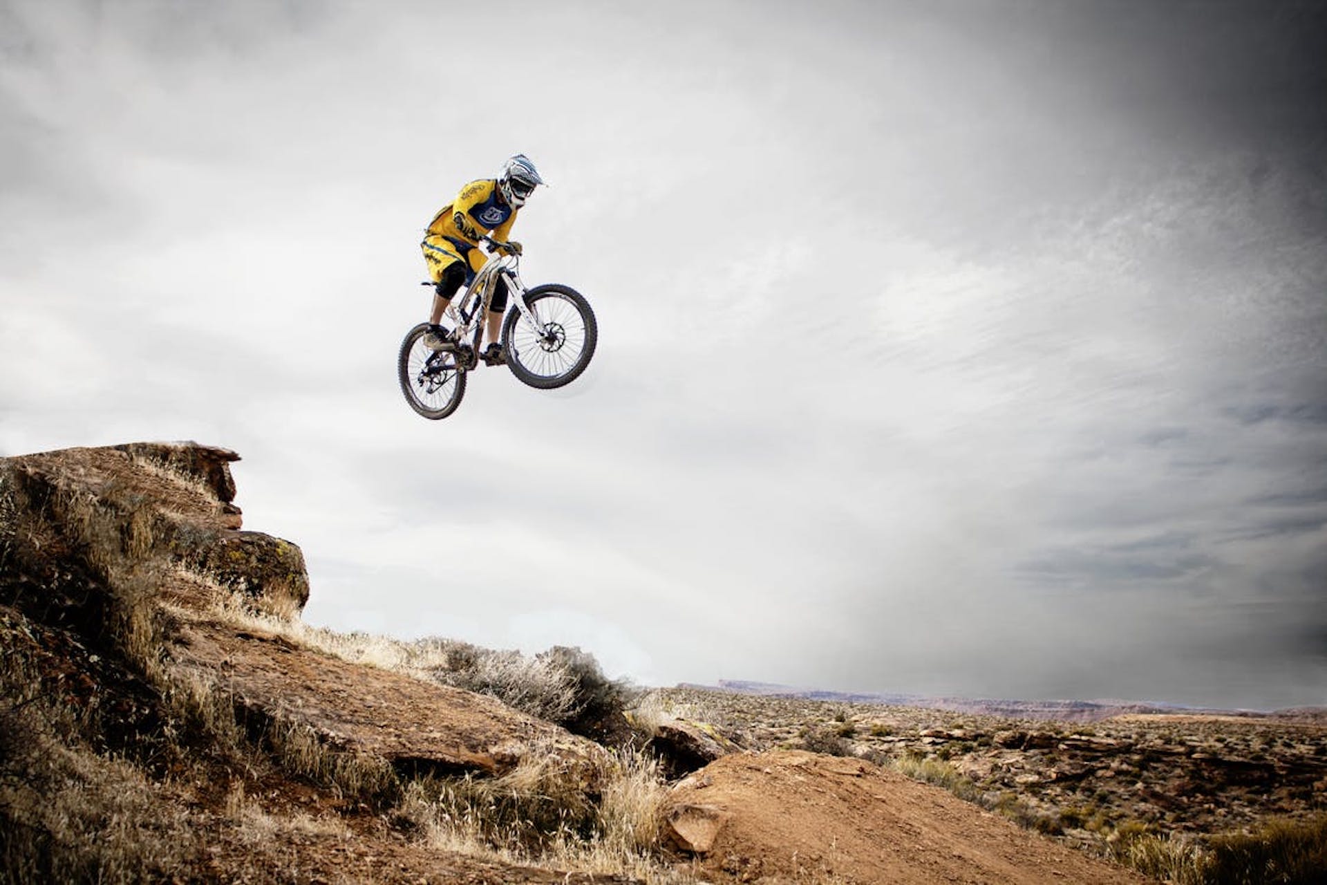 jumping a hill on a mountain bike in the desert